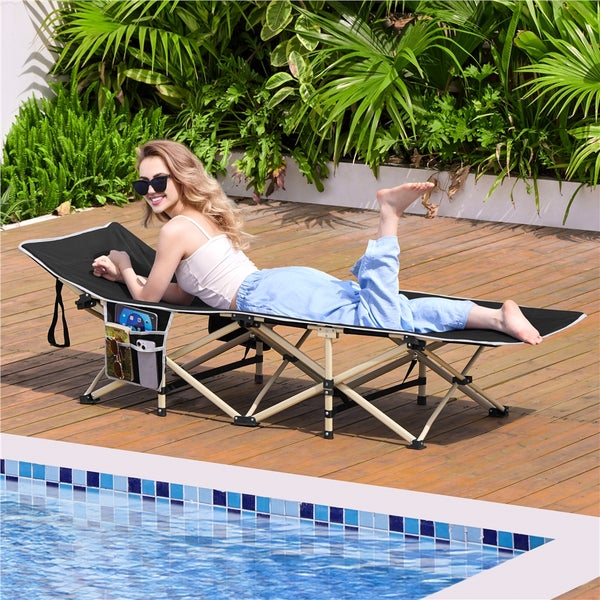 Frau liegt auf einer klappbaren Sonnenliege mit Seitentasche neben einem Pool