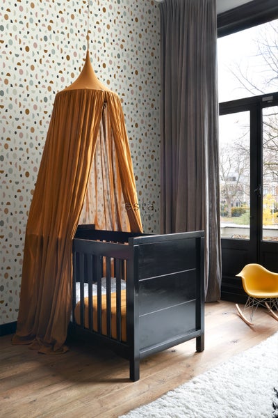 Kinderzimmer mit Babybett, Baldachin und gemusterter Tapete