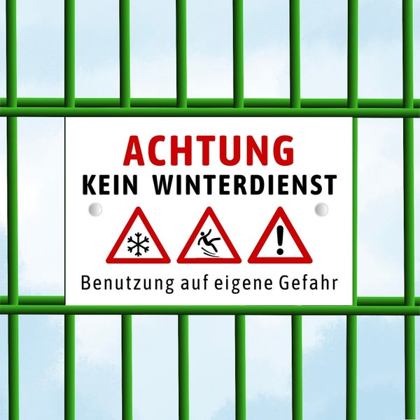 Schild auf Gitterzaun mit dem Text Achtung, kein Winterdienst und Warnsymbolen für Schnee, Rutschgefahr und allgemeine Gefahr