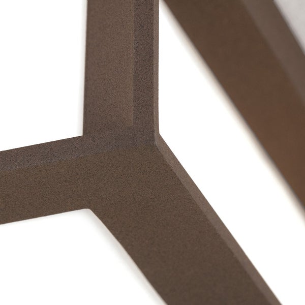 Detailaufnahme eines braunen, strukturierten geometrischen Wandelements mit matter, körniger Oberfläche.
