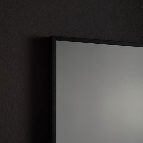Wandspiegel mit schwarzem Rahmen, Detailansicht der Ecke.