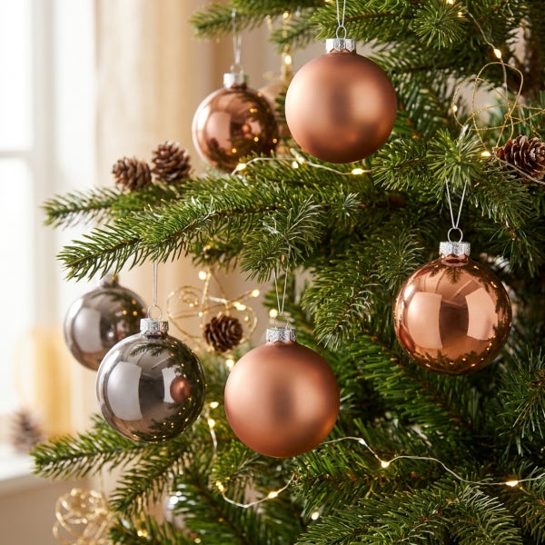 Weihnachtsbaum geschmückt mit glänzenden und matten Christbaumkugeln und einer Lichterkette in einem Tannenbaum