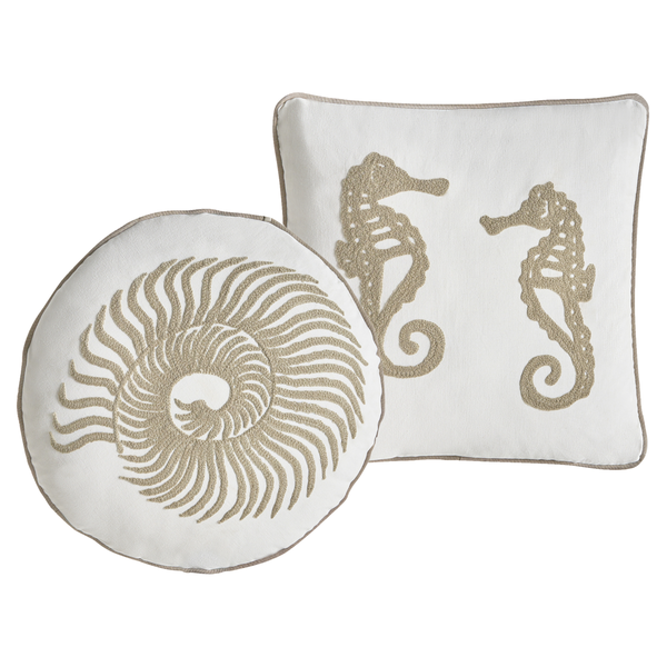 Dekorative Kissen mit Meeresmotiven, ein rundes Kissen mit Muscheldekor und ein quadratisches Kissen mit Seepferdchenmotiv.