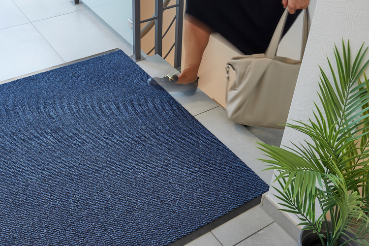 Blaue Fußmatte im Eingangsbereich eines Hauses.