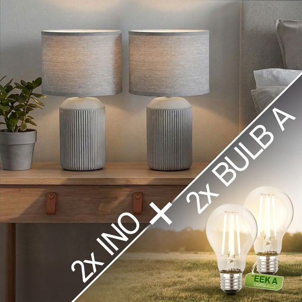 Zwei Tischleuchten Ino mit geriffeltem Sockel und Stoffschirm sowie zwei LED-Leuchtmittel Bulb A der Energieeffizienzklasse A.