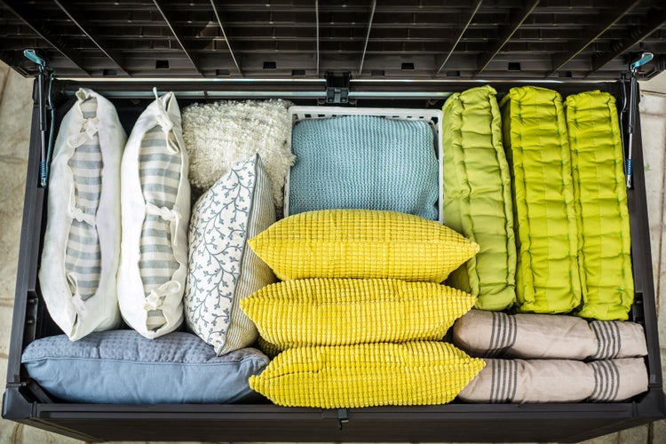 Geöffnete Aufbewahrungsbox mit verschiedenen Kissen und Textilien.