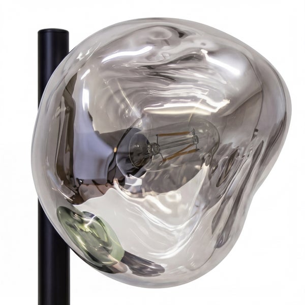 Moderne Leuchte mit unregelmäßig geformtem, verspiegeltem Glasschirm und sichtbarem LED-Leuchtmittel an einem schwarzen Ständer.