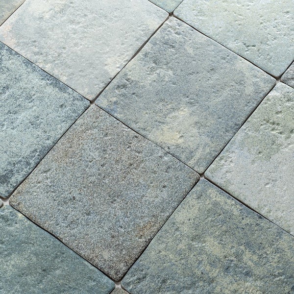 Quadratische Bodenfliesen mit einer strukturierten Oberfläche im Steinoptik Design.