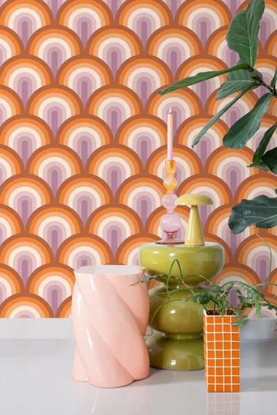 Szene mit Retro-Tapete, Beistelltisch, Kerzenständer und Zimmerpflanzen, die einen stilvollen Wohnraum zeigt