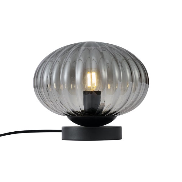 Moderne Tischleuchte mit rundem geripptem Rauchglasschirm und schwarzem Sockel.