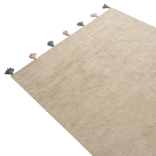 Ein rechteckiger Teppich mit flauschiger Textur und dekorativen Quasten an einer Kante.
