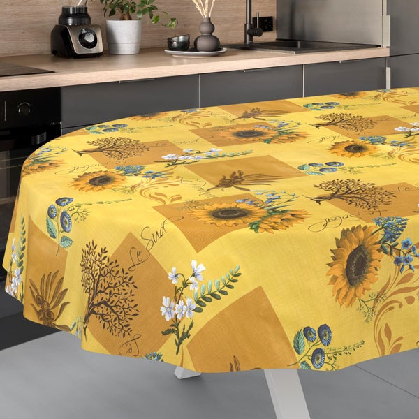 Runde Tischdecke mit Sonnenblumen-, Oliven- und Baummustern auf einem Tisch in einer modernen, hellen Küche.