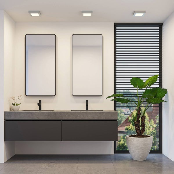 Modernes Badezimmer mit Doppelwaschtisch, dunkelgrauem Unterschrank, zwei Spiegeln mit schwarzem Rahmen, schwarzen Armaturen und Deckenleuchten.