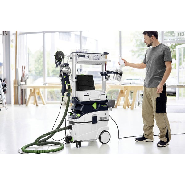 Festool Absaugmobil CLEANTEC mit Workcenter WCR 1000, Systainern und Zubehör in einer hellen, organisierten Werkstatt mit einer Person.