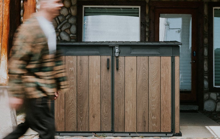 Geräteschrank mit Holztüren vor einem Haus