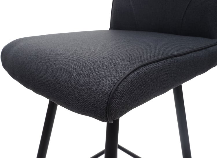 Detailaufnahme eines Barhockers mit Stoffbezug und Metallbeinen.