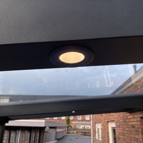 Einbauleuchte integriert in einen Terrassendachbalken, die warmes Licht ausstrahlt.