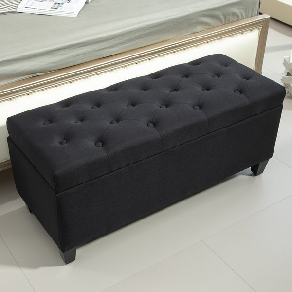 Gepolsterte Aufbewahrungsbank mit Knopfdesign neben einem Bett