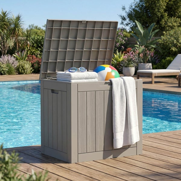 Graue Gartenbox in Holzoptik mit offenem Deckel auf einer Holzterrasse am Pool, gefüllt mit Handtüchern, Schwimmbrille und Wasserball.