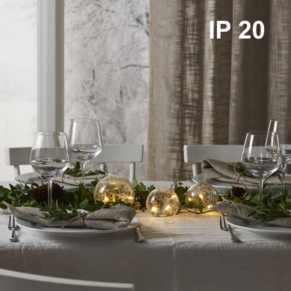 Festlich gedeckter Tisch mit Kugelleuchten und dem Symbol IP20.