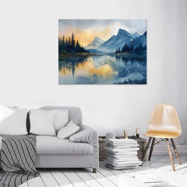 Wandbild mit Aquarellmotiv von Bergen und Wald an einer Wohnzimmerwand über einem Sofa mit Kissen und einer Decke.