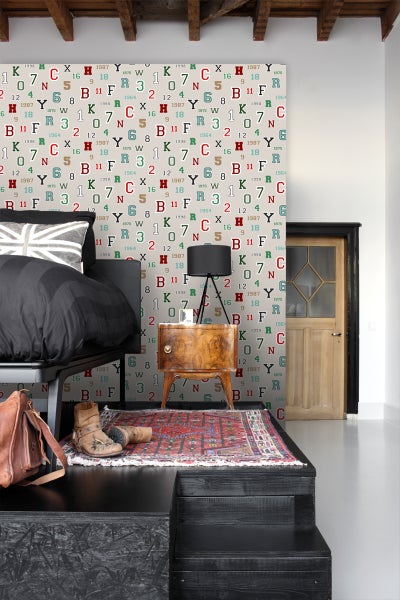 Einrichtungsidee für ein Schlafzimmer mit einem Bett, einem Nachttisch und einer gemusterten Tapete