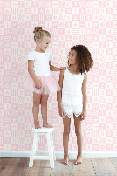 Zwei Mädchen vor einer Wand mit Buchstaben- und Zahlentapete