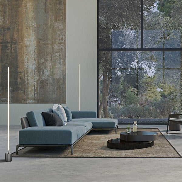 Helles Wohnzimmer mit blauer Eckcouch, abstraktem Gemälde und großem Fenster