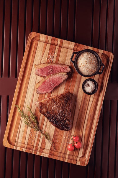 Gegrilltes Steak mit Beilagen auf einem Holzbrett