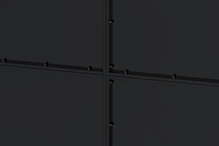 Nahaufnahme einer schwarzen Metallrahmen-Konstruktion für Glaselemente im industriellen Stil mit Befestigungspunkten.
