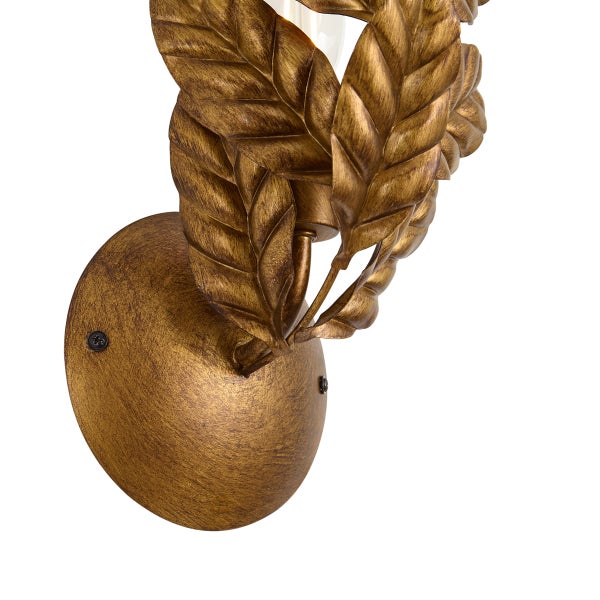 Wandleuchte aus Metall mit dekorativen Blättern in Goldoptik.