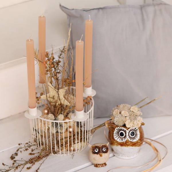 Dekorative Anordnung mit Kerzen, Trockenblumen und Eulenfiguren