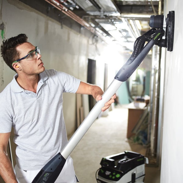 Person befestigt Schleifpapier an einem Exzenterschleifer