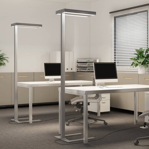 Zwei moderne LED-Büro-Stehlampen aus Metall an Schreibtischen in einem hellen, organisierten Arbeitszimmer mit Computern und Aktenordnern.