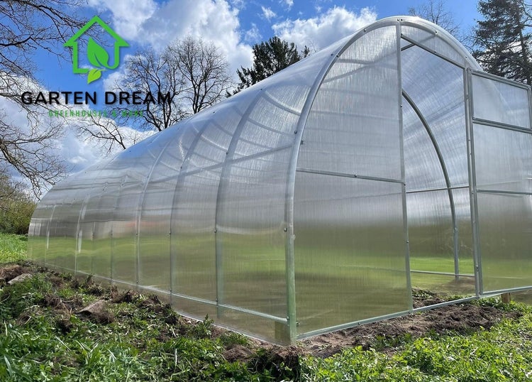 Großes bogenförmiges Gewächshaus mit Polycarbonat-Platten und Metallrahmen im Garten. Garten Dream Logo.