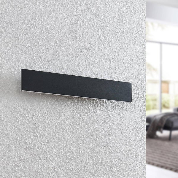 Moderne, schwarze Außenwandleuchte in rechteckiger Form an einer strukturierten Wand montiert.