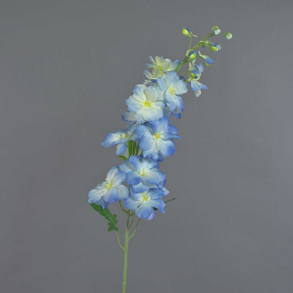 Kunstblume Rittersporn mit mehreren blauen Blüten an einem grünen Stiel.