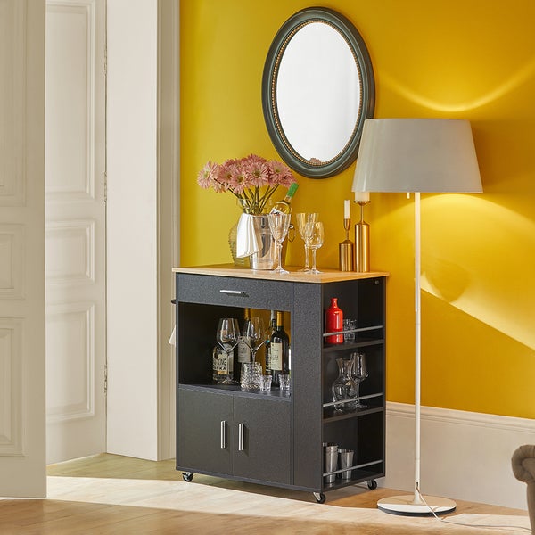 Servierwagen mit Flaschen, Gläsern und Dekoration in einem Wohnraum.