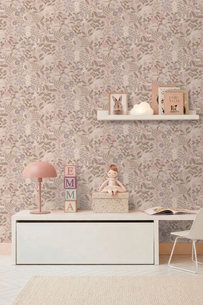 Hell gestaltetes Kinderzimmer mit floral gemusterter Tapete, weißem Schreibtisch, Wandregal, einer Lampe und dekorativen Spielsachen.