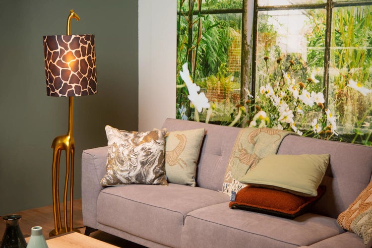 Wohnzimmer mit Sofa, Kissen und einer Stehlampe im Giraffen Design