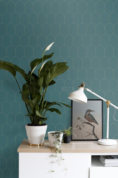 Dekoratives Interieur mit Zimmerpflanzen, Lampe und gemusterter Tapete für ein gemütliches Ambiente