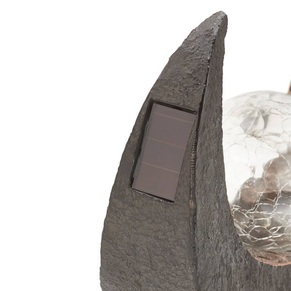 Nahaufnahme einer Solar-Gartenleuchte mit integriertem Solarpanel und einer Glaskugel in Bruchglas-Optik.