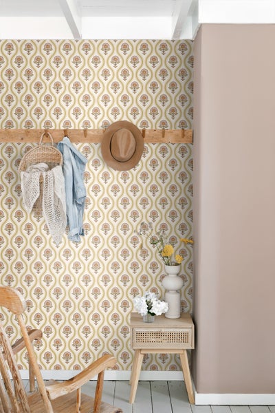 Dekoratives Zimmer mit gemusterter Tapete, Holzgarderobe und Beistelltisch