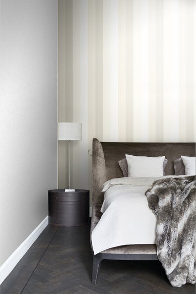 Schlafzimmer mit Bett, Nachttisch und gestreifter Tapete für ein stilvolles Ambiente.