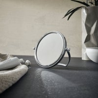 Kosmetikspiegel auf einer Ablage mit Kosmetikartikeln