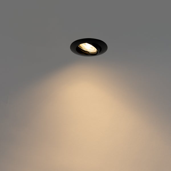 Schwarzer LED-Einbaustrahler eingeschaltet mit warmweißem Lichtkegel.