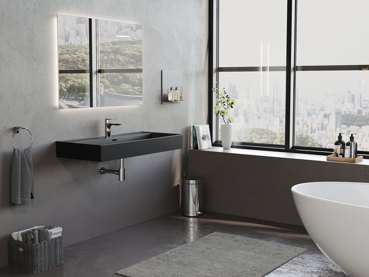 Badezimmer mit schwarzem Waschtisch, Spiegel mit Beleuchtung und freistehender Badewanne