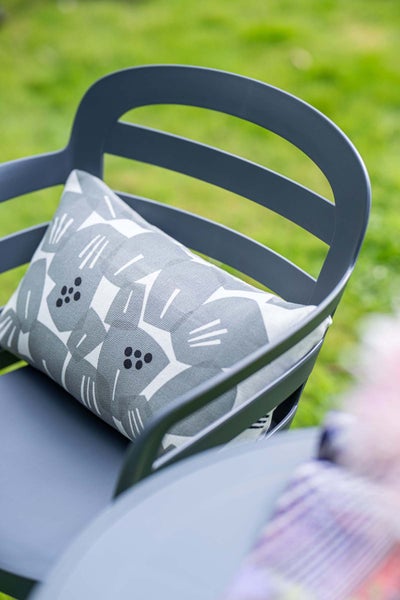 Dunkelgrauer Gartenstuhl mit einem grau-weiß gemusterten Kissen und einer Rückenlehne mit Querstreben.