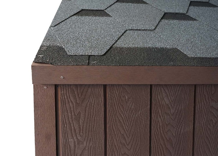 Detailansicht eines Gerätehauses mit Dachschindeln und Holzverkleidung.