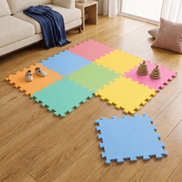 Mehrfarbige Puzzlematte als Spielteppich auf einem Holzboden in einem Wohnzimmer.